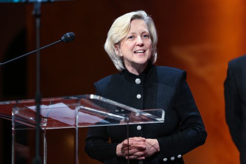 image of Kyle Zimmer, CEO of First Book, speaking in front of a glass podium.