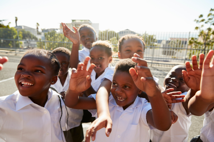 group of happy children in a playground, smiling and laughing