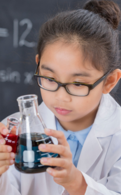 young female student in a science class with a beaker