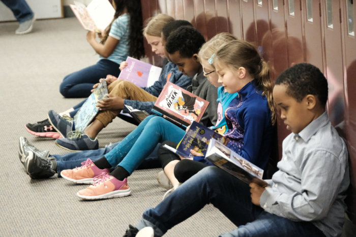 group of kids reading at their lockers