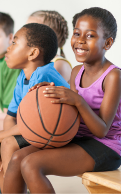 black girl sitting with a basketball on a bench, skill building