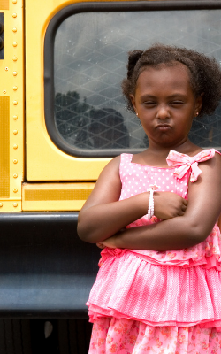 young black girl unhappy in front of a school bus, skill building