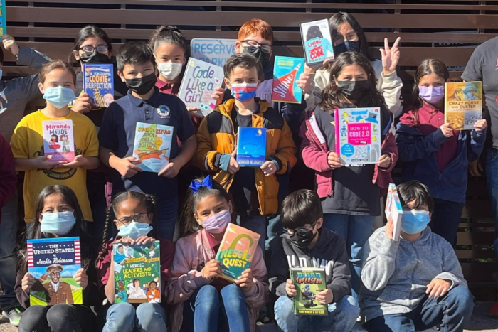 group of kids in masks holding books
