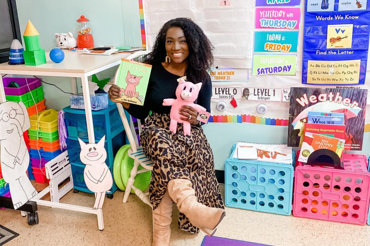 teacher holding Mo Willems' Piggie and Elephant book and a piggie plush toy