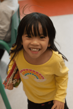 excited young girl holding a Dora the Explorer book
