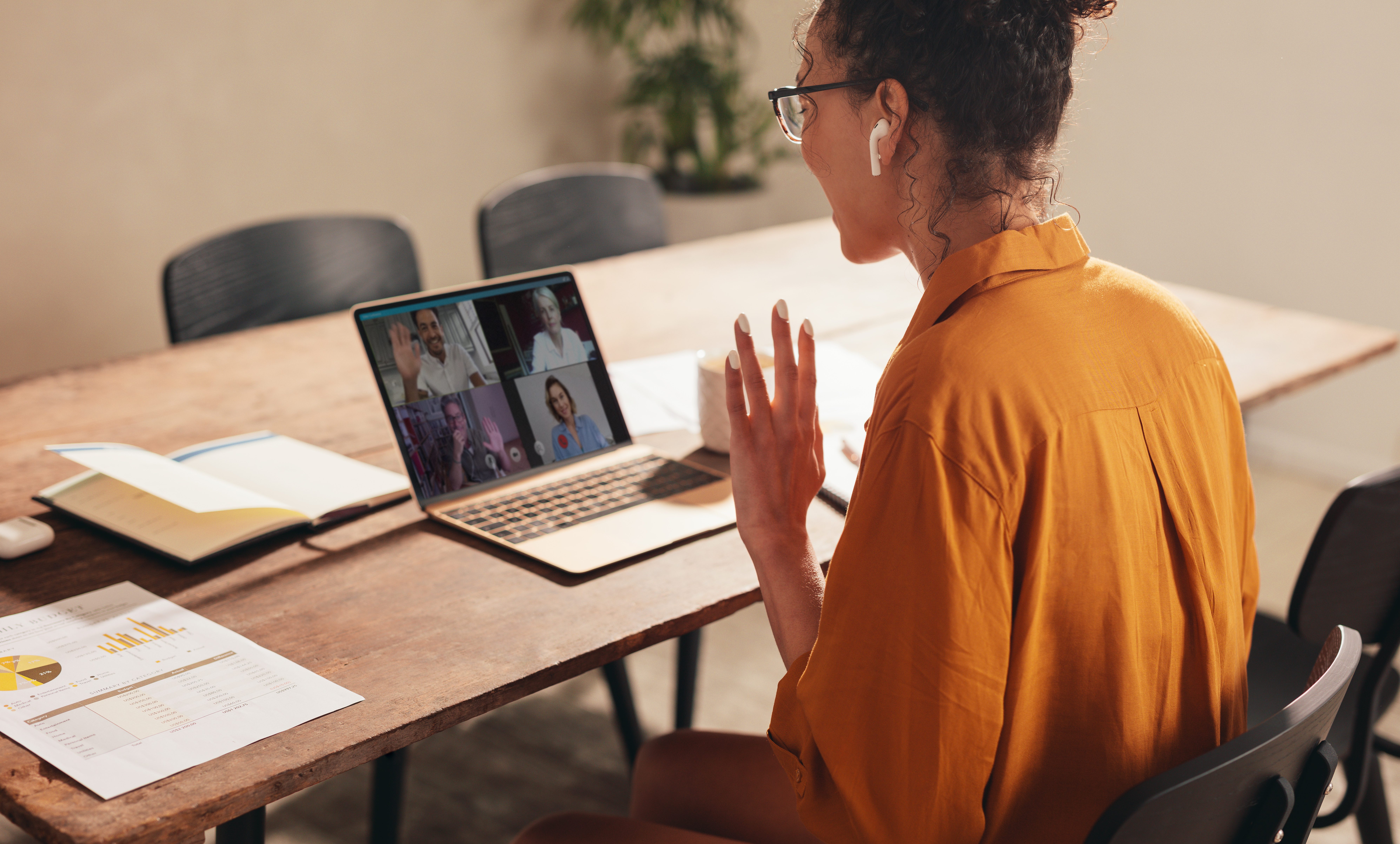 Businesswoman at home having a video conference call with colleagues. Woman greeting coworker during a web conference.